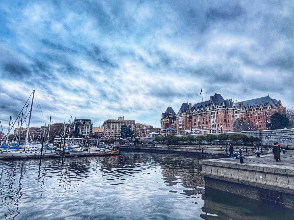 Scenic view of Victoria Inner Harbour featuring the historic Fairmont Empress Hotel and docked boats at the marina